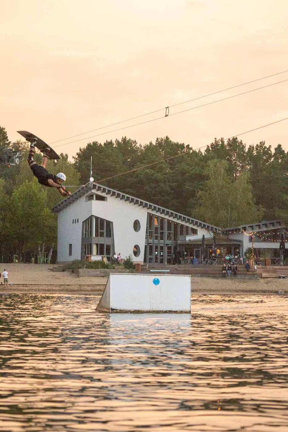 Wakeboarder am Kicker vor dem Clubhaus